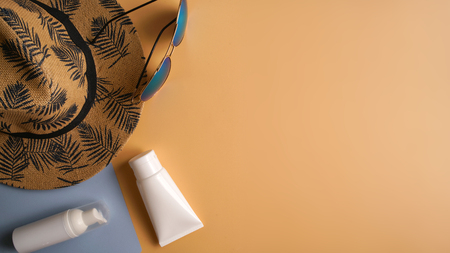 Flat lay, top view workspace with eye glasses, notebook, hat, sun block, shoes and coffee cup on yellow background. Summer stylish traveller blogger concept.の写真素材