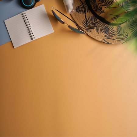 Flat lay, top view workspace with eye glasses, notebook, hat, sun block, shoes and coffee cup on yellow background. Summer stylish traveller blogger concept.の写真素材