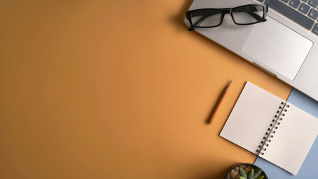 Flat lay, top view workspace with eye glasses, notebook, hat, sun block, shoes and coffee cup on yellow background. Summer stylish traveller blogger concept.の写真素材