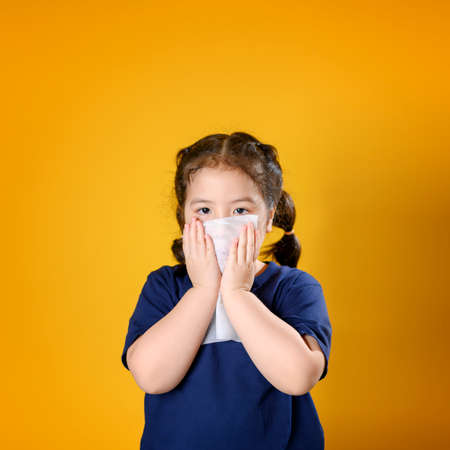 Little asian girl sick and sad with sneezing on nose and cold cough on tissue paper becauseweak or virus and bacteria from dust weather and kindergarten and kindergarten school for medical.の写真素材