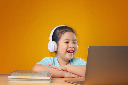 A Happy little asian girl studying online learning class with online video call zoom teacher at home. E-learning or Home schooling education concept. New normal.Covid-19 coronavirus.Social distancing.の写真素材