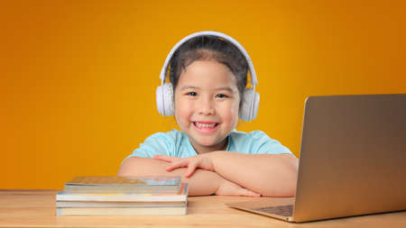 A Happy little asian girl studying online learning class with online video call zoom teacher at home. E-learning or Home schooling education concept. New normal.Covid-19 coronavirus.Social distancing.の写真素材