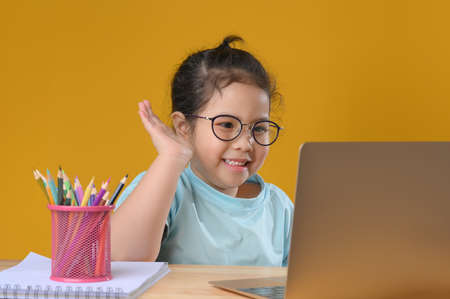 A Happy little asian girl studying online learning class with online video call zoom teacher at home. E-learning or Home schooling education concept. New normal.Covid-19 coronavirus.Social distancing.の写真素材