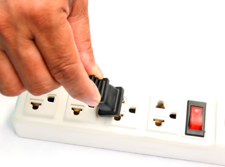 Hand inserting black electrical plug