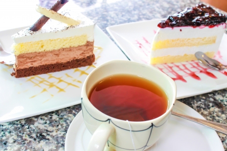 Cake  two piece with cup of tea on tableの写真素材