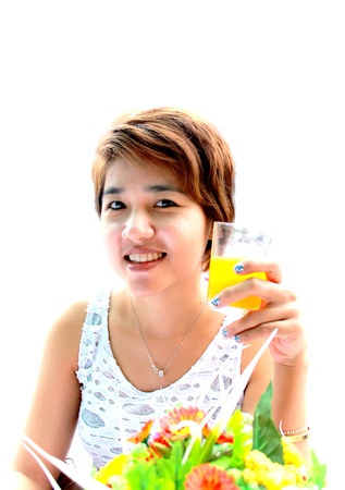 Asian girl short hair. drinking a glass of orange juiceの写真素材