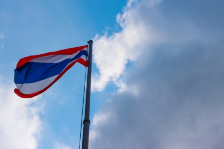 Image of waving Thai flag of Thailand with blue sky background の写真素材
