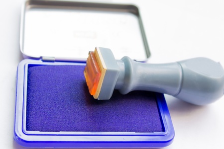 Rubber stamp with stamp pad in front of a white backgroundの写真素材