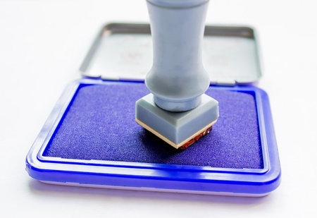 Rubber stamp with stamp pad in front of a white backgroundの写真素材