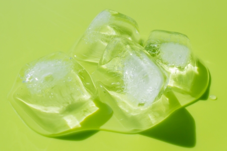 Green background with ice cubesの写真素材