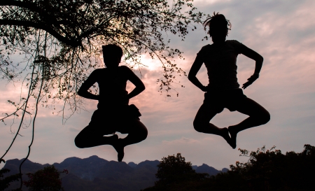 Two people jumping on the mountainの写真素材