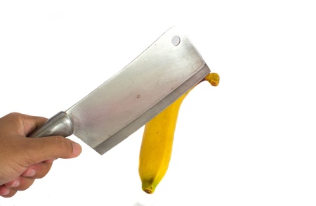 Cleaver slicing of banana on white groundの写真素材