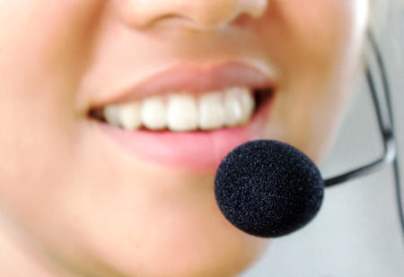 Beautiful young call-center assistant smiling , isolatedの写真素材