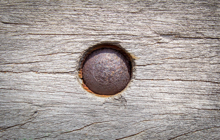 rusty nut on a piece of old wood textureの写真素材