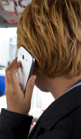 Woman with short brown hair  She talking on a mobile phone