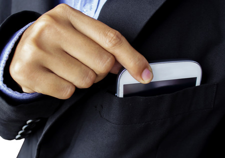 Business woman wearing elegant suit take smartphone from pocketの写真素材