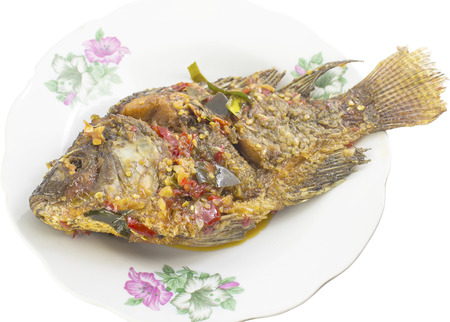 fried fish with fresh herbs and sweet spicy sauce in dish on white backgroundの写真素材
