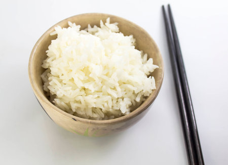 rice with chopsticks in a cup on white backgroundの写真素材
