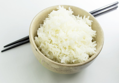 rice with chopsticks in a cup on white backgroundの写真素材