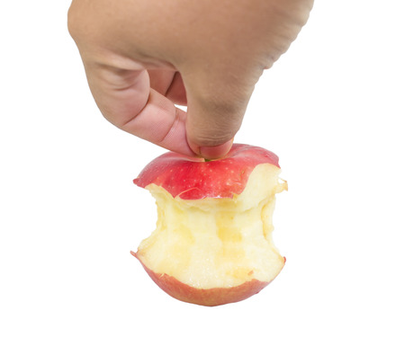 Bite red apple core in hand on a white backgroundの写真素材