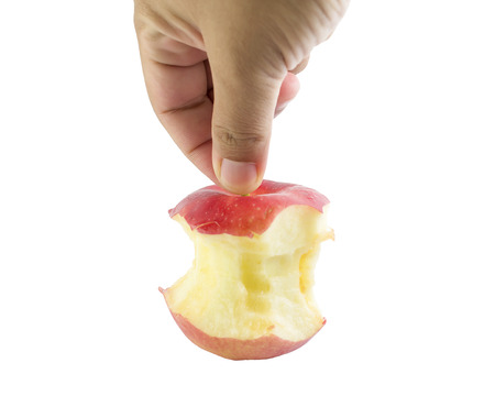 Bite red apple core in hand on a white backgroundの写真素材
