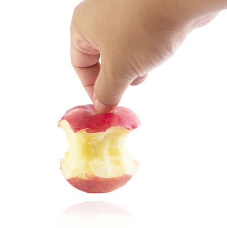 Bite red apple core in hand on a white backgroundの写真素材