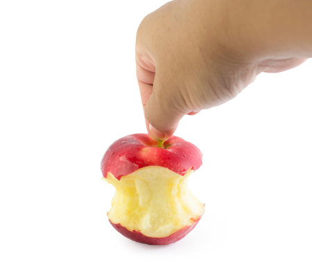 Bite red apple core in hand on a white backgroundの写真素材