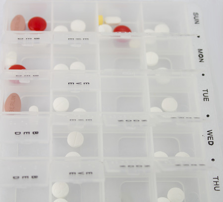 Daily and Weekly pill box with selection of medicationの写真素材