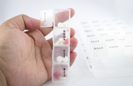 Hand holding a pill box and open up the morning boxの写真素材