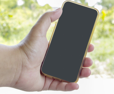 Close up of a human using mobile smart phone on nature backgroundの写真素材