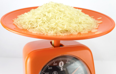rice on a orange kilo scales with a white backgroundの写真素材
