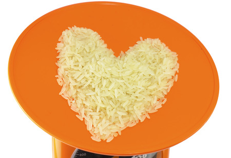 Brown rice heart symbol on orange dish Backgroundの写真素材