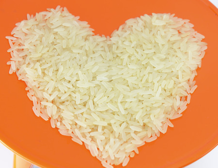 Brown rice heart symbol on orange dish Backgroundの写真素材