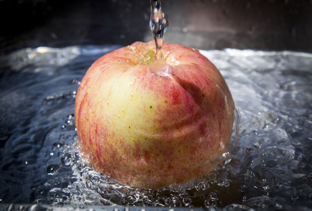 Apple in spray of waterの写真素材