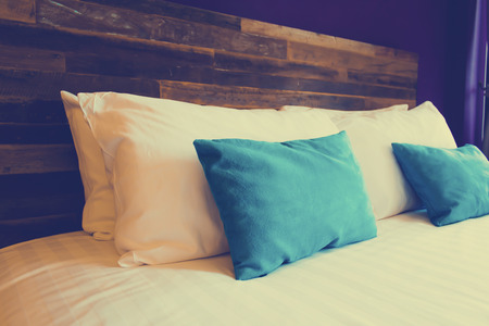 White and blue pillows on a bed Comfortable soft pillows on the bedの写真素材
