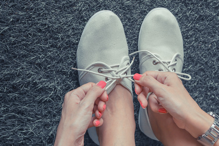 Close up of woman pink nail tying shoelace,black and white toneの写真素材