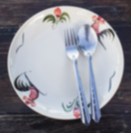 ceramic dishes thai old-style  and spoon and fork  on wood background,image blur styleの写真素材