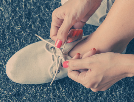 Close up of woman pink nail tying shoelace,vintage toneの写真素材