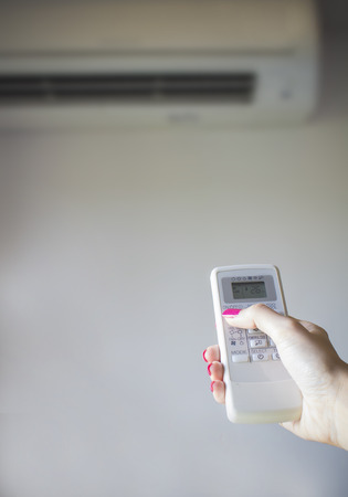 Hand of woman remote control air-conditionerの写真素材