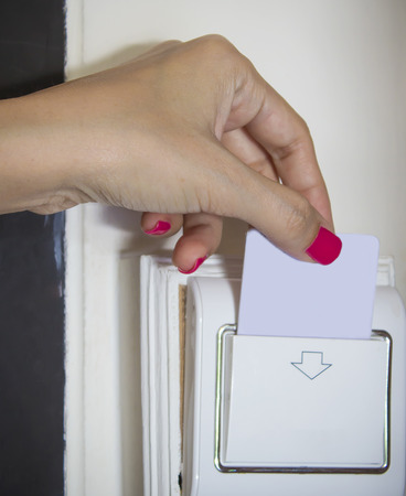 Female hand touch keycard on hotel doorの写真素材