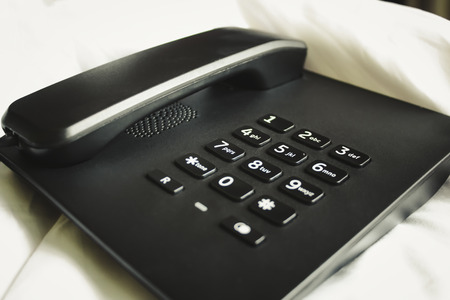 Black telephone on the bed