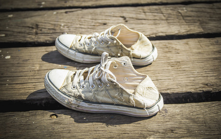 pair of old sneakers on wood backgroundの写真素材
