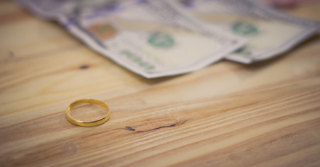 Golden  rings and dollar banknotes on table background. Love and finance conceptの写真素材