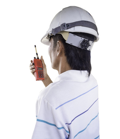 Engineer using walkie talkie and looking away  isolated on white.の写真素材