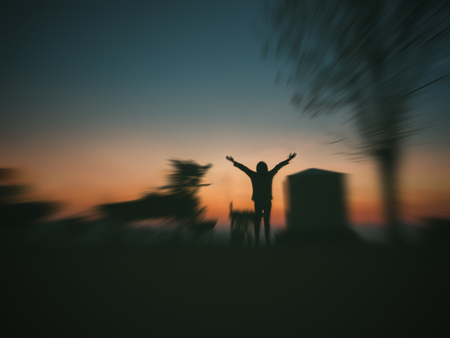 woman open arms under the sunrise ,Image blurry styleの写真素材