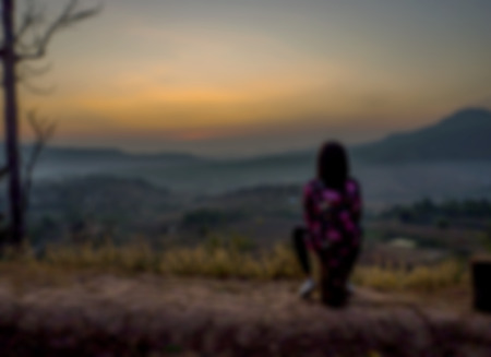 Woman sit see to the sunrise,Image blur style.の写真素材