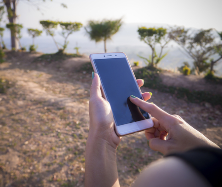 Mobile phones in the hands of the mountains and wild.の写真素材