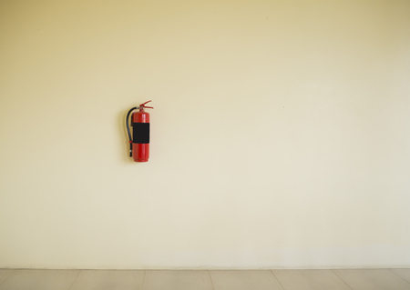 red fire extinguisher tank on  wall backgroundの写真素材