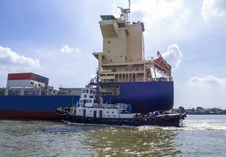 Logistics and transportation of International Container Cargo ship with tugboat