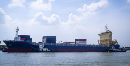 Logistics and transportation of International Container Cargo ship with tugboatの写真素材